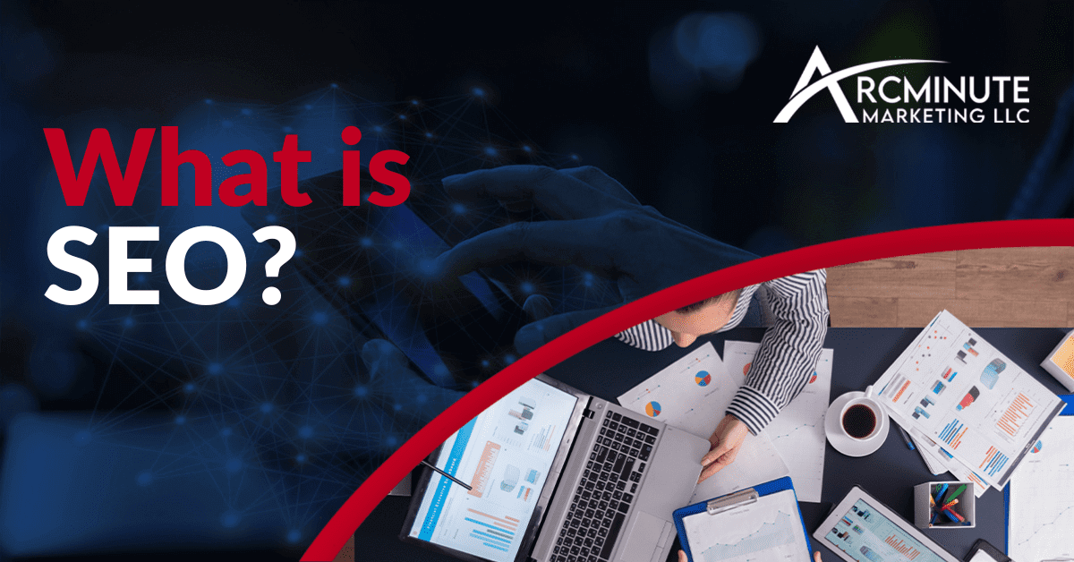 Business Meeting With A Person Pointing At A Laptop With Documents, A Cup of Coffee, and Pens On The Table| What is SEO? | Arcminute Marketing